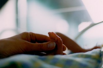 Image of parent's hand touching a baby's foot